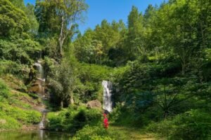 Air terjun kembar Coban Putri dengan kolam tenang dan vegetasi hijau yang rimbun, menghadirkan suasana ruang pulih alami