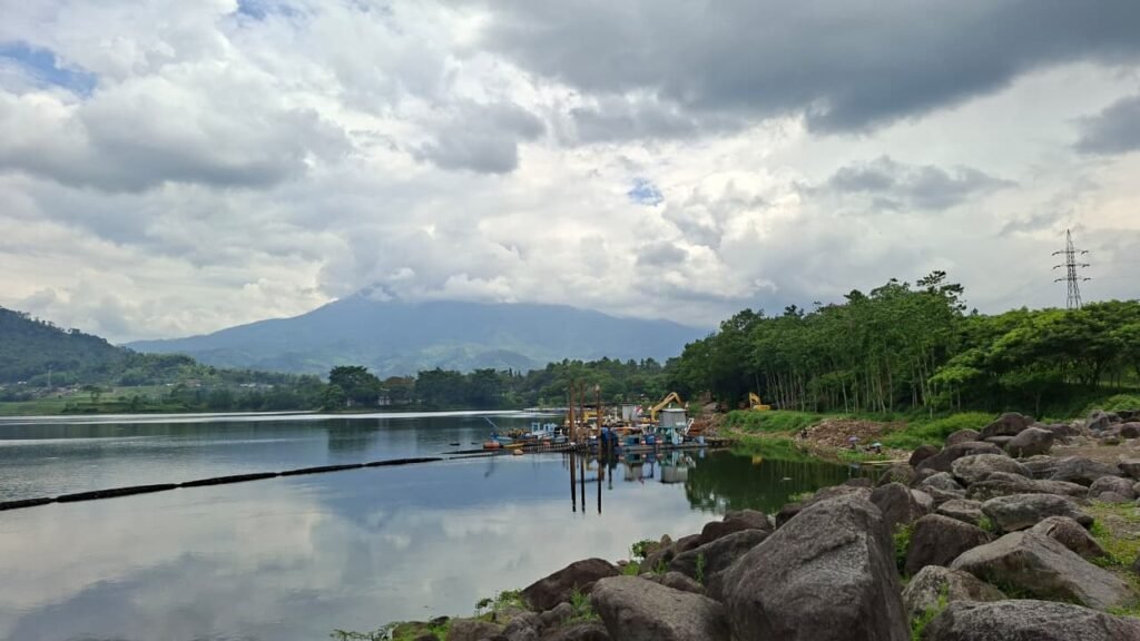 Suasana Bendungan Selorejo di tepi waduk dan perbukitan hijau.